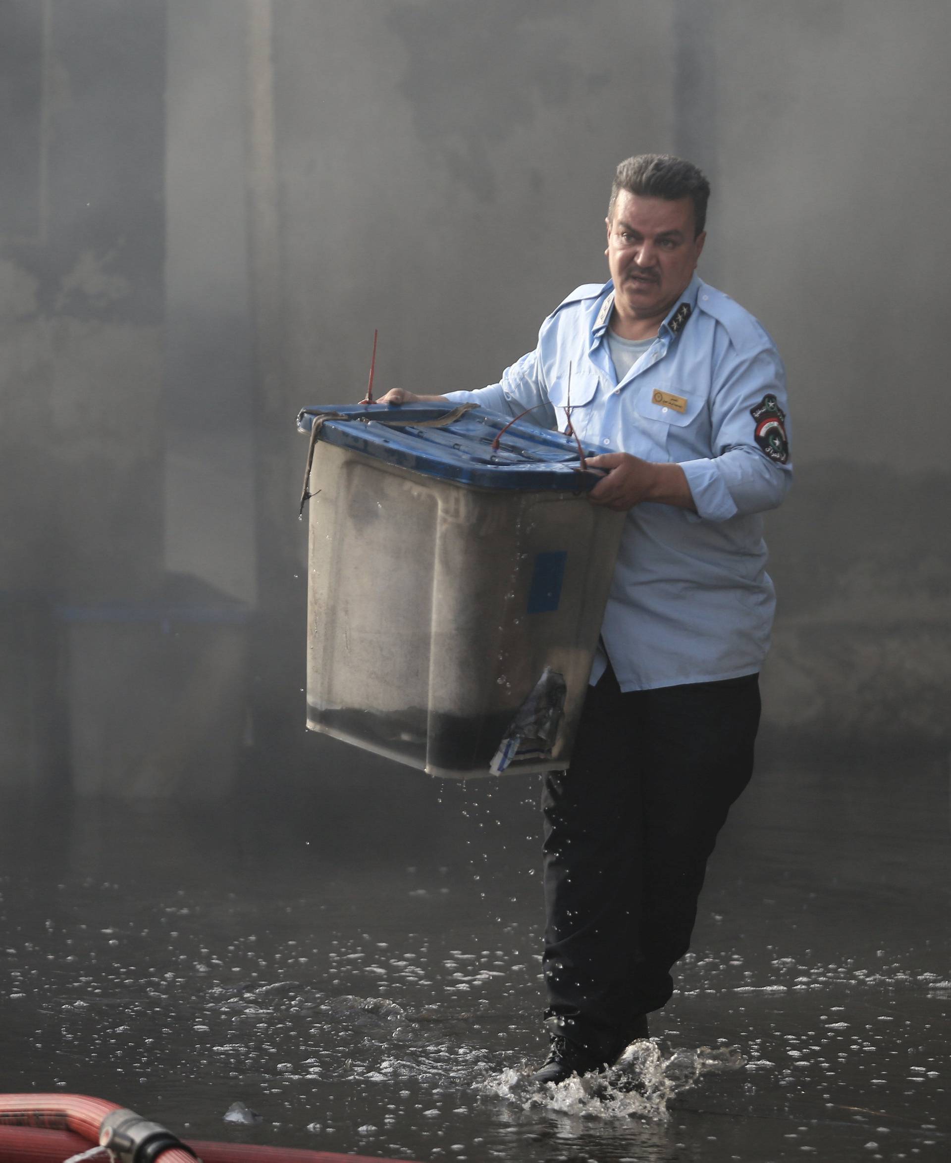 Official carries a ballot box, after a fire at a storage site in Baghdad, housing the boxes from Iraq's May parliamentary election