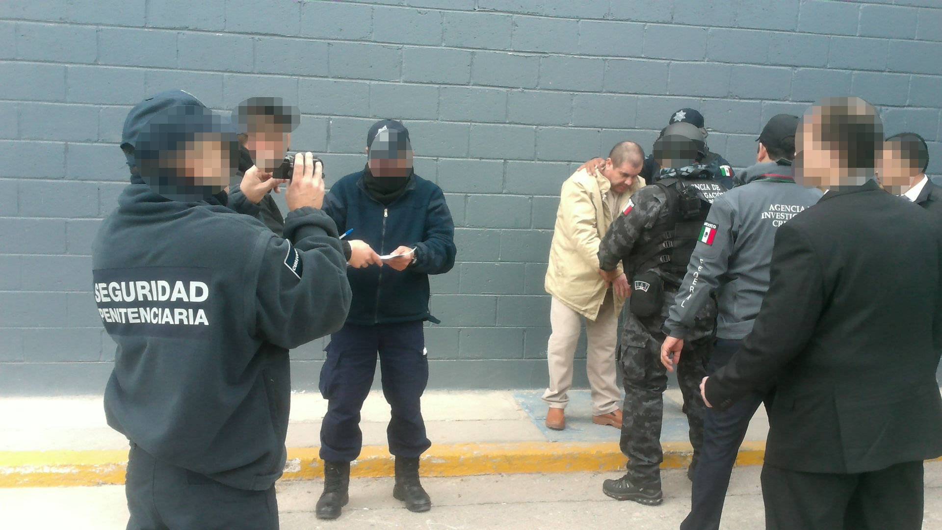 Mexico's top drug lord Joaquin "El Chapo" Guzman is escorted by police officers in Ciudad Juarez, Mexico, as he is extradited to New York
