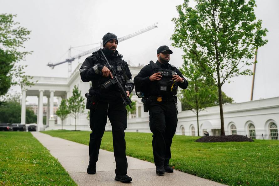 U.S. Secret Service agents walk at the White House after alleged gunshots were heard nearby, at the White House in Washington