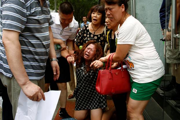 A family member of a passenger aboard Malaysia Airlines flight MH370 which went missing in 2014 reacts during a protest outside the Chinese foreign ministry in Beijing