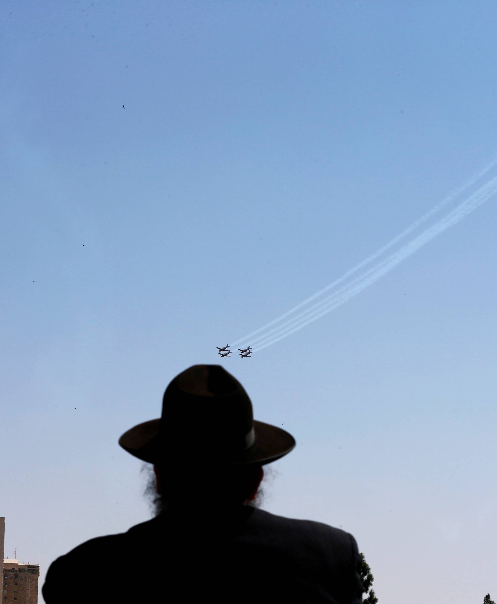 An Ultra Orthodox Jewish man looks at an Israeli Air Force aerobatic team flying in formation during a rehearsal for an aerial show for Israel's 70th Independence Day celebrations, in Jerusalem