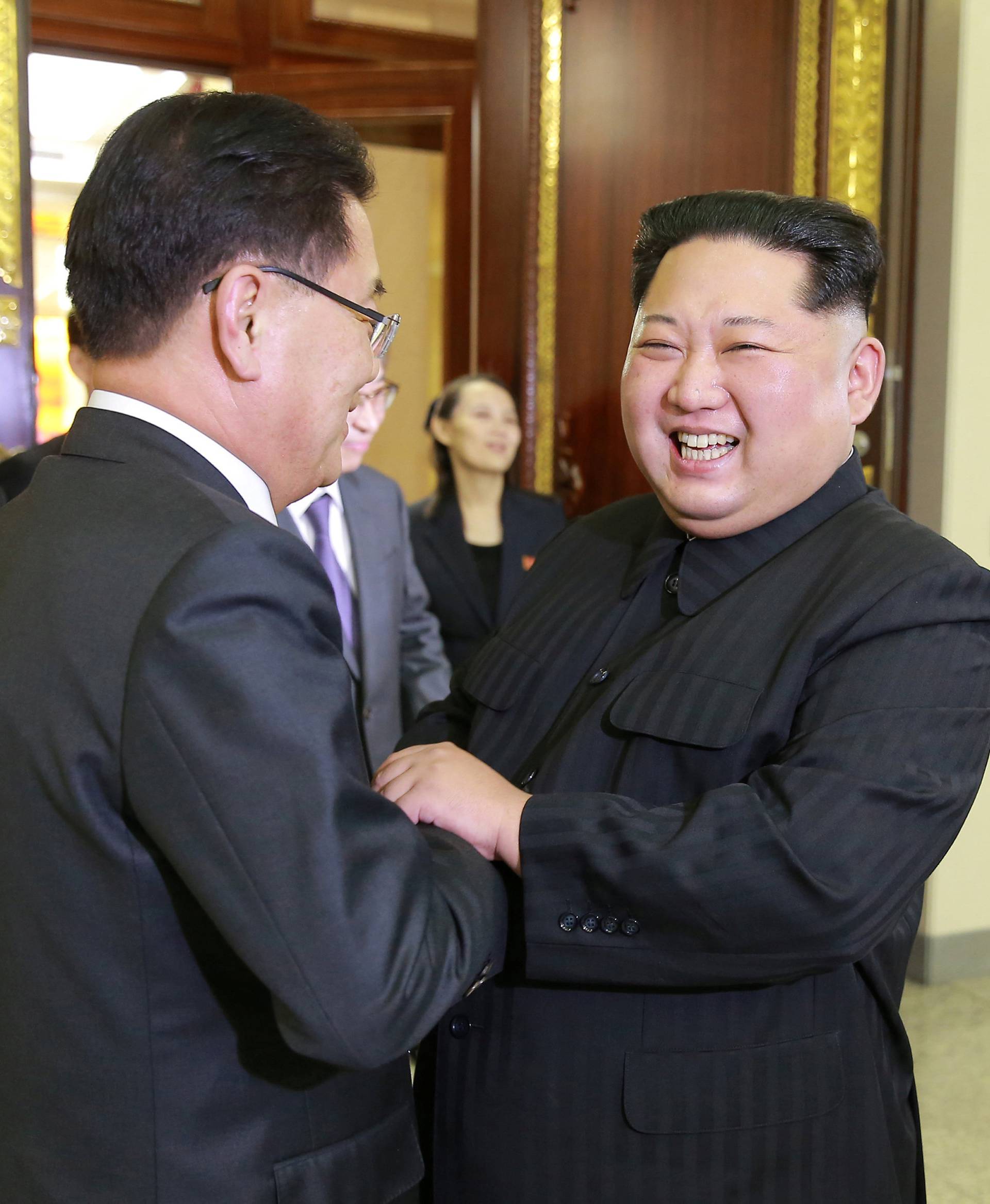 North Korean leader Kim Jong Un greets a member of the special delegation of South Korea's President at a dinner in this photo released by North Korea's Korean Central News Agency