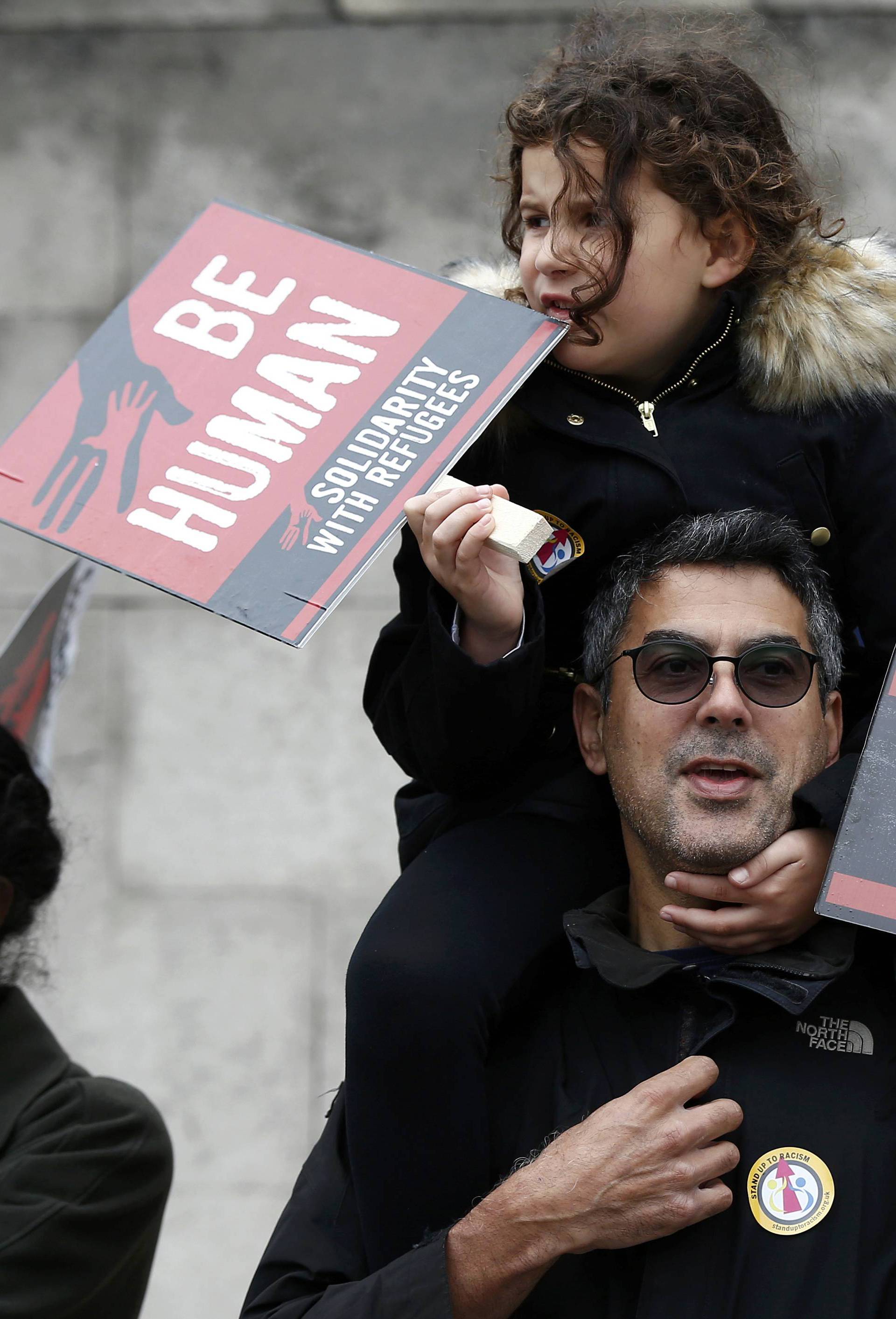 Demonstrators march to the Houses of Parliament during a protest in support of refugees, in London