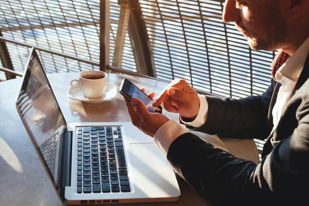 Businessman,Using,Smartphone,And,Laptop