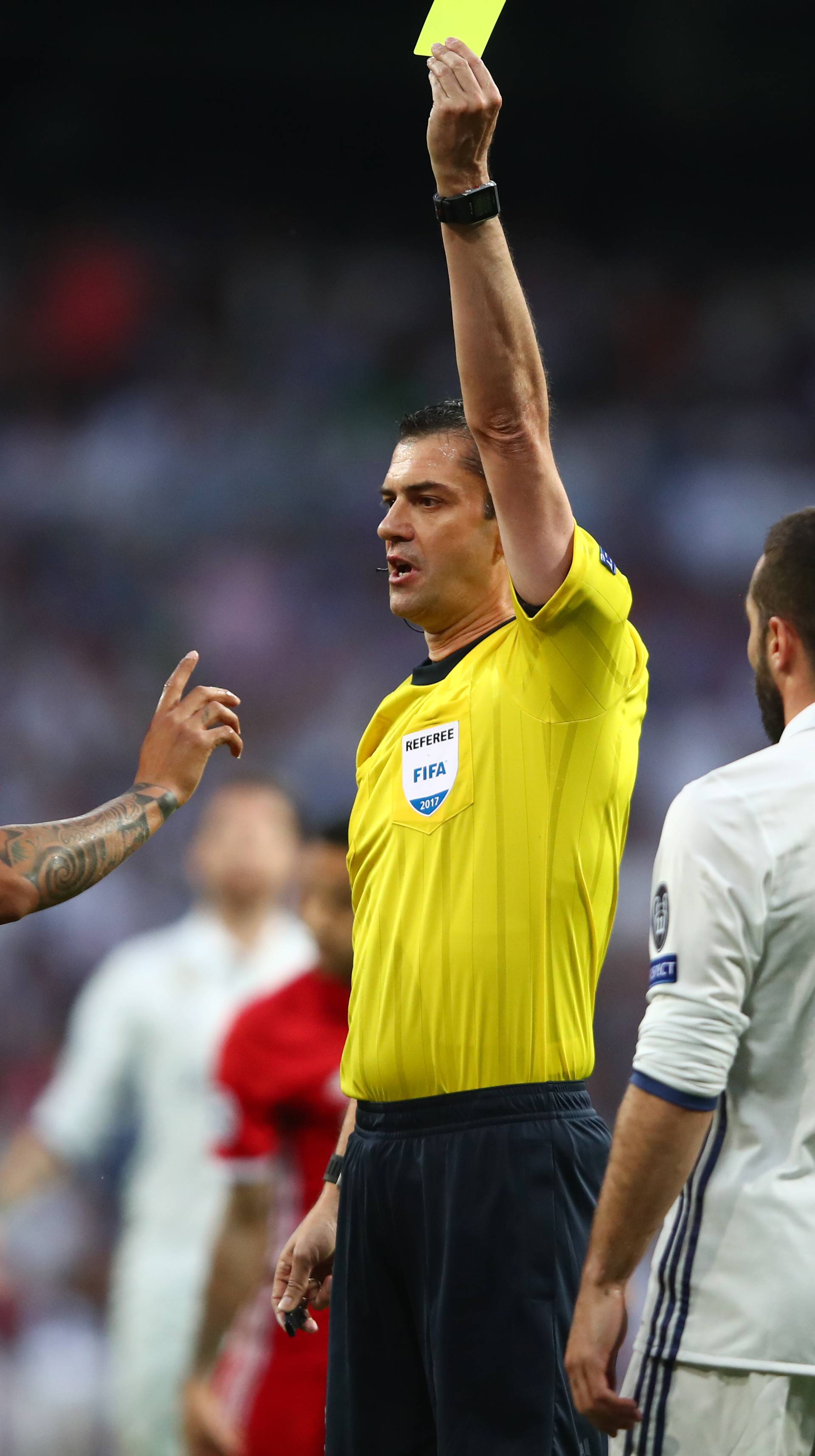 Bayern Munich's Arturo Vidal is shown a yellow card by referee Viktor Kassai