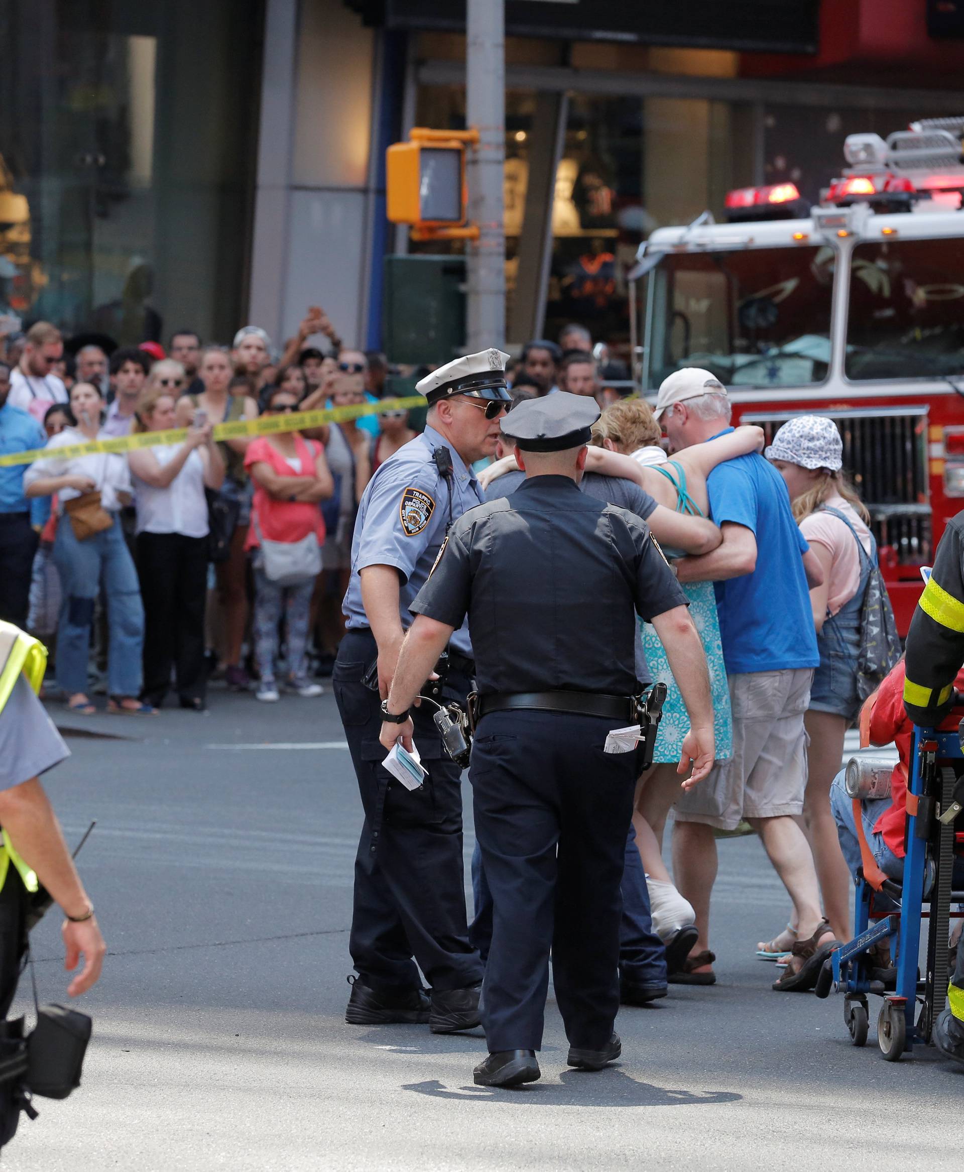 First responders tend to injured pedestrians after a vehicle struck pedestrians on a sidewalk in Times Square in New York