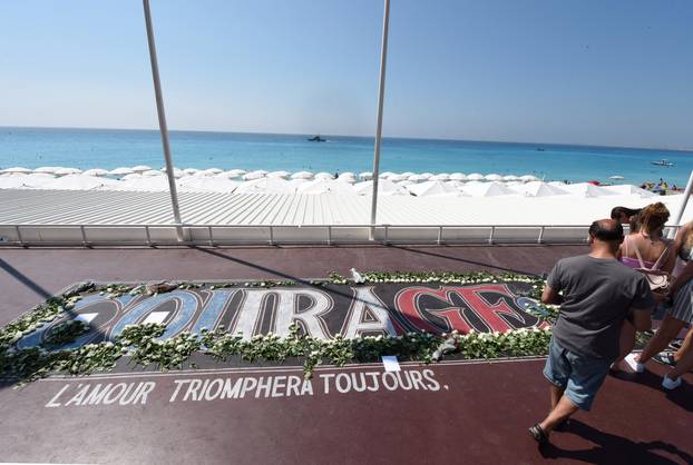 Tourists walk along the Promenade des Anglais as part of the commemorations of last year