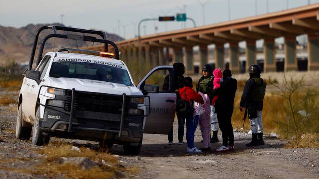 Members of the Mexican National Guard call on migrants from Haiti to withdraw from the banks of the Rio Bravo river as they try to control the influx of migrants crossing toward the U.S., in Ciudad Juarez