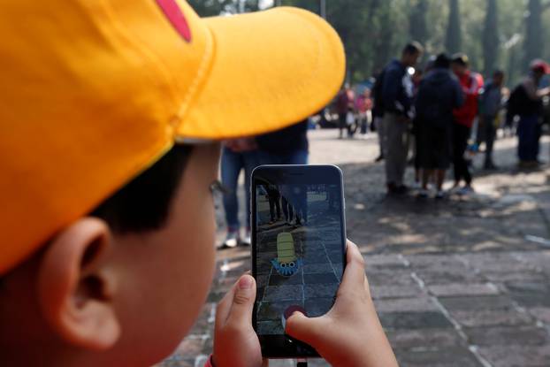 A child plays Pokemon Go during a gathering to celebrate "Pokemon Day" in Mexico City, Mexico 