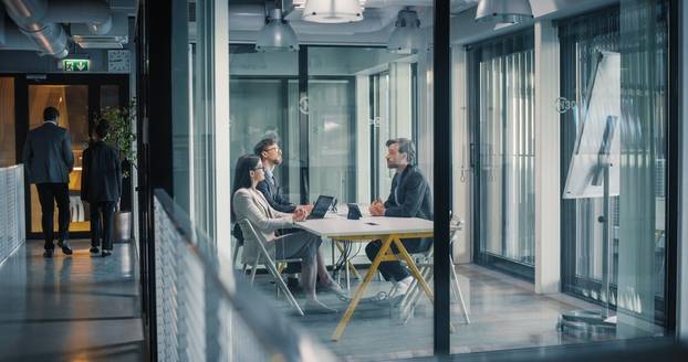 Business,Team,Sits,In,A,Glass,Meeting,Room,,Discussing,Project