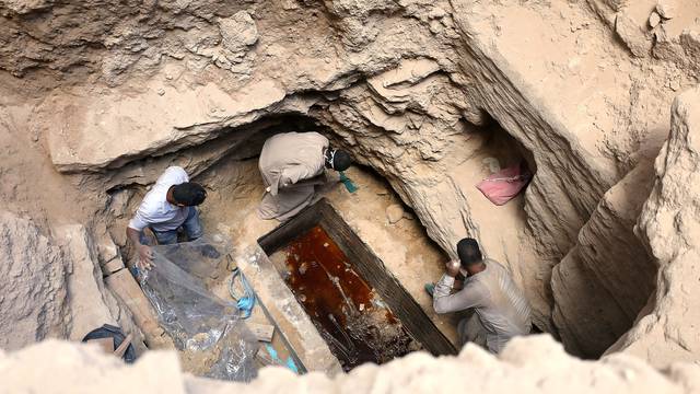 Archaeologists unearth coffin containing three mummies with sewage water and bones inside, in Alexandria