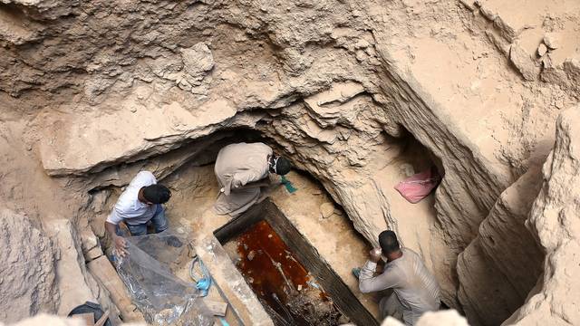 Archaeologists unearth coffin containing three mummies with sewage water and bones inside, in Alexandria