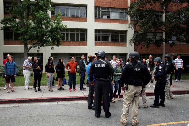 Police officers interview witnesses after conducting a search on people at the University of California, Los Angeles (UCLA) campus after it was placed on lockdown following reports of a shooter in Los Angeles