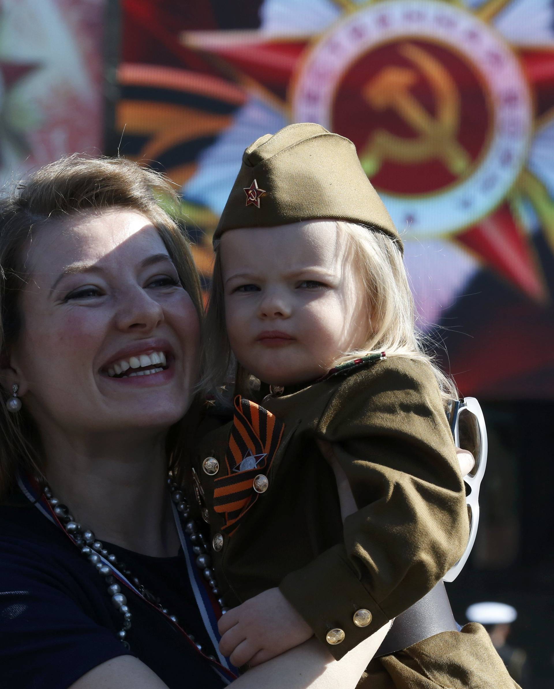 Woman and girl dressed in historical Red Army uniform wait before watching Victory Day parade to mark end of World War Two at Red Square in Moscow