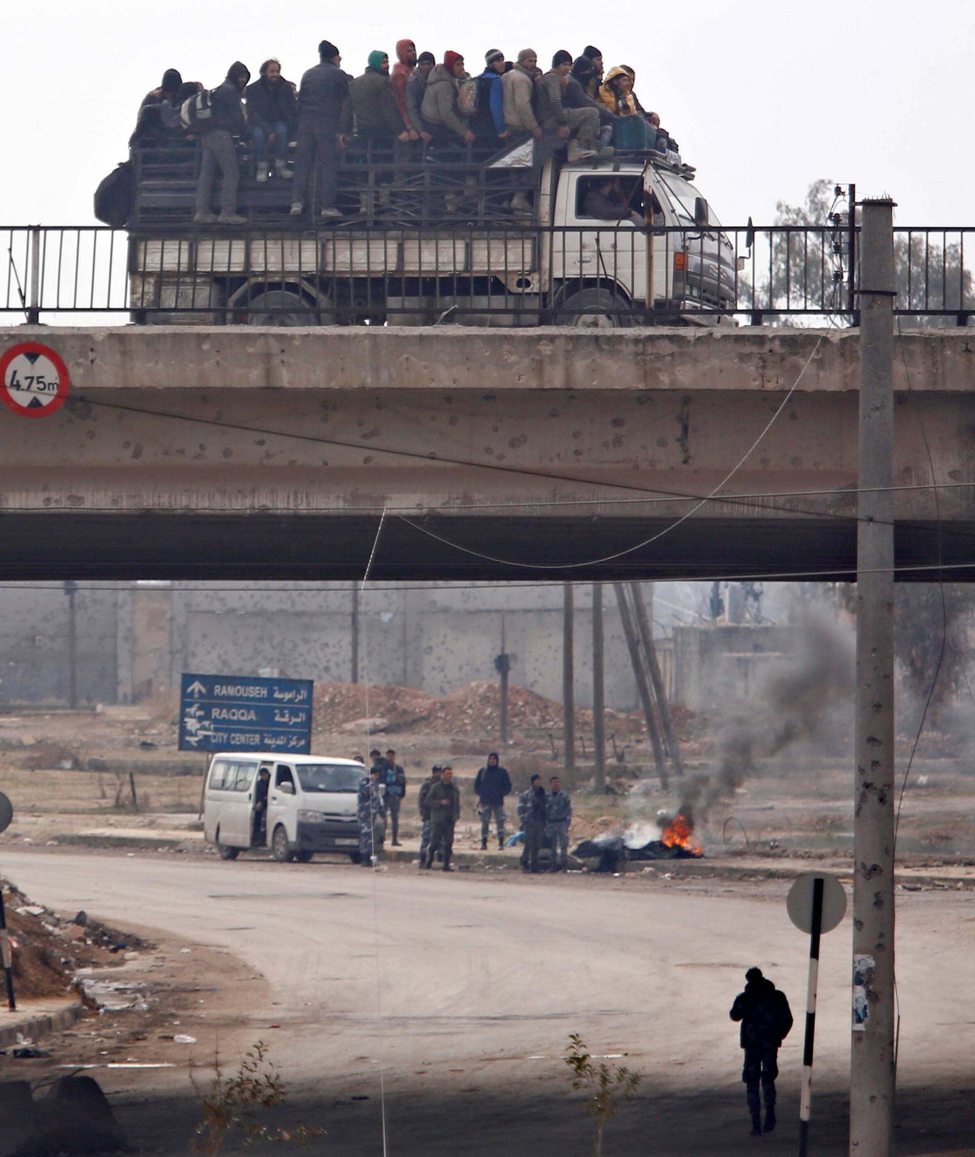 Evacuees from rebel-held eastern Aleppo ride on pick-up along the government-held area of al-Ramousah bridge