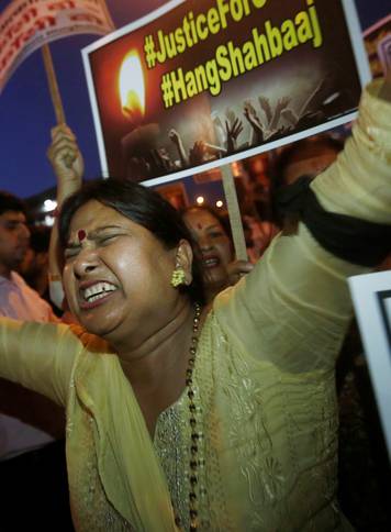 A woman shouts slogans during a protest against the rape of a ten-year-old girl, in the outskirts of Delhi