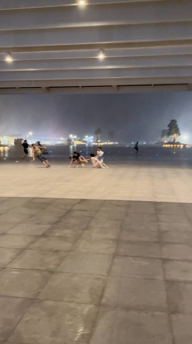 People seek shelter from wind near Zhuhai Opera house building, during typhoon Wipha, in Zhuhai