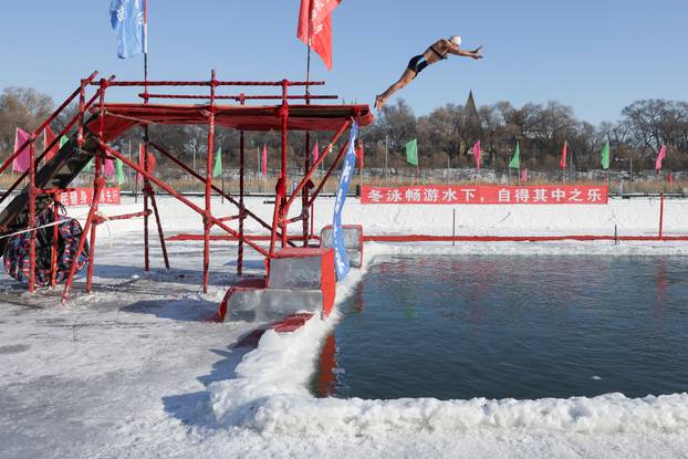 Locals participate in winter swimming events during annual ice and snow sculpture festival, in Harbin