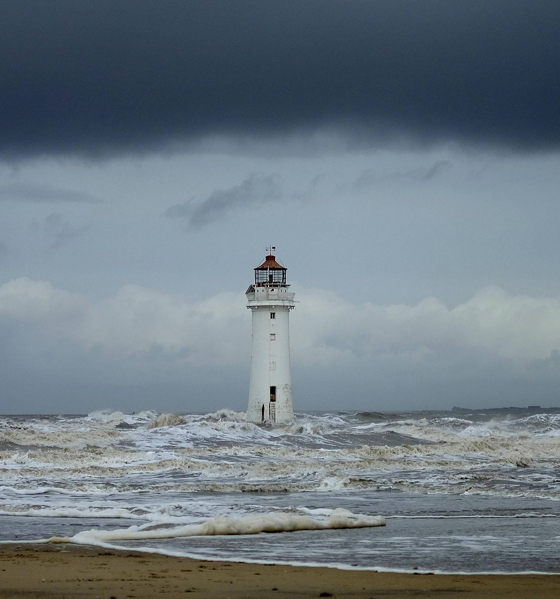 Storm clouds gather above Perch Rock lighthouse in New Brighton, northern England.