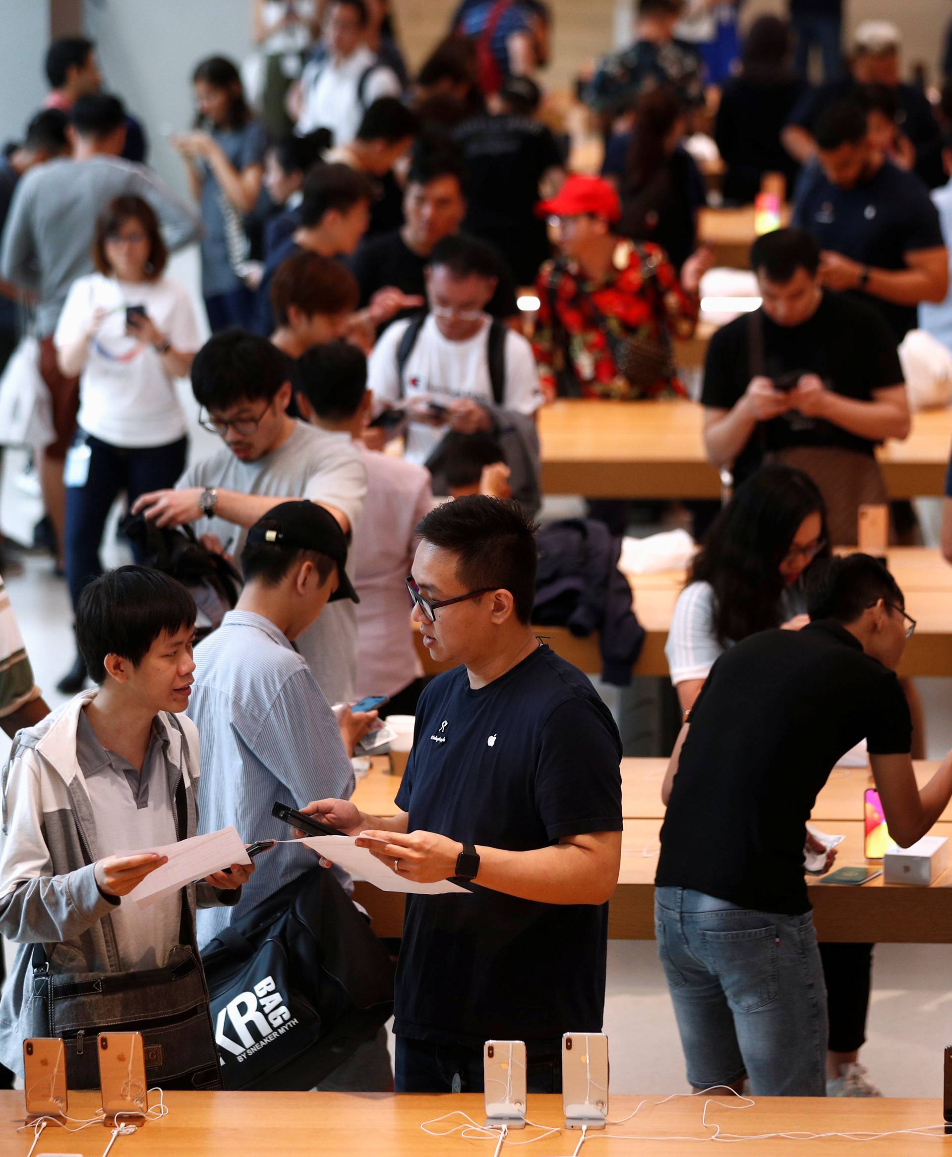 Customers look at the newly launched iPhone XS and iPhone XS Max at the Apple Store in Singapore