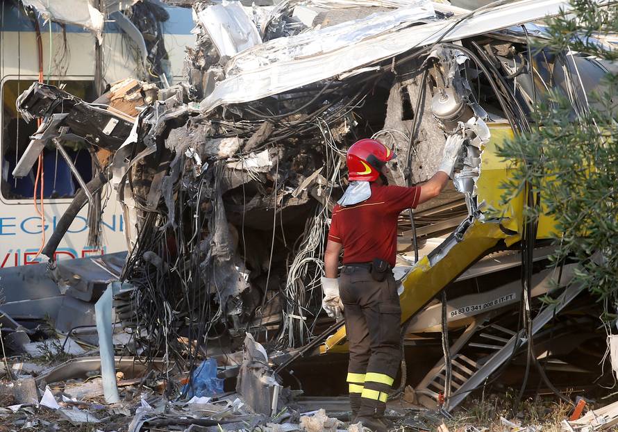 A firefighter works at the site where two passenger trains collided in the middle of an olive grove in the southern village of Corato