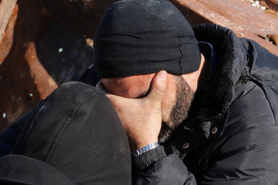 A man reacts as he waits with others to be evacuated from a rebel-held sector of eastern Aleppo