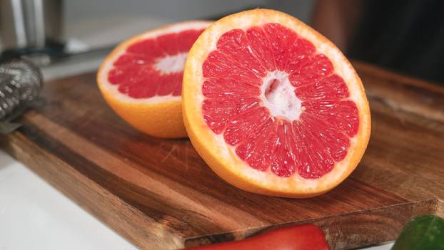 Grapefruit,Cut,In,Two,Close,Up,On,A,Wooden,Chopping