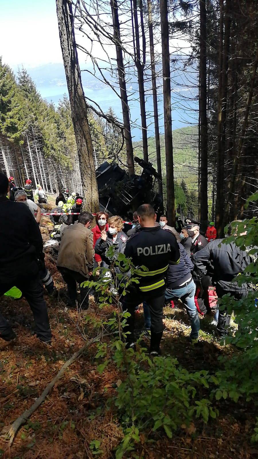 Police and rescue service members are seen near the crashed cable car after it collapsed in Stresa