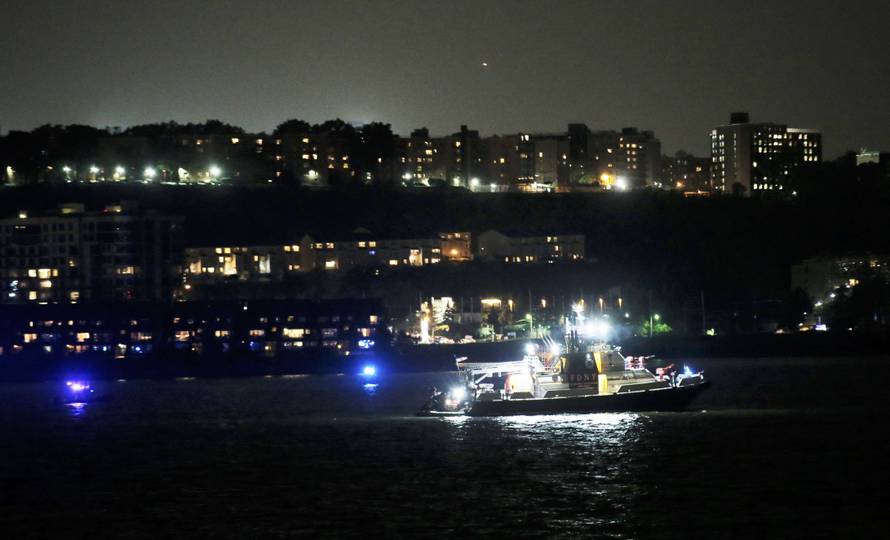 An FDNY fire department boat searches the Hudson River for the wreckage of a vintage P-47 Thunderbolt airplane that crashed in the river in New York City