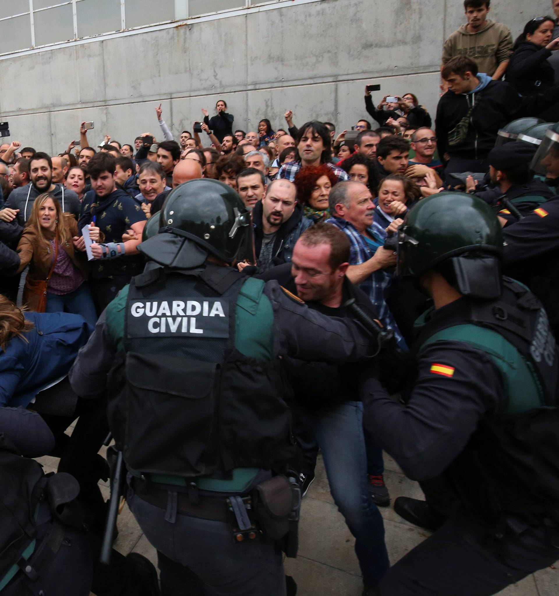People scuffle with Spanish Civil Guard officers outside a polling station for the banned independence referendum in Sant Julia de Ramis