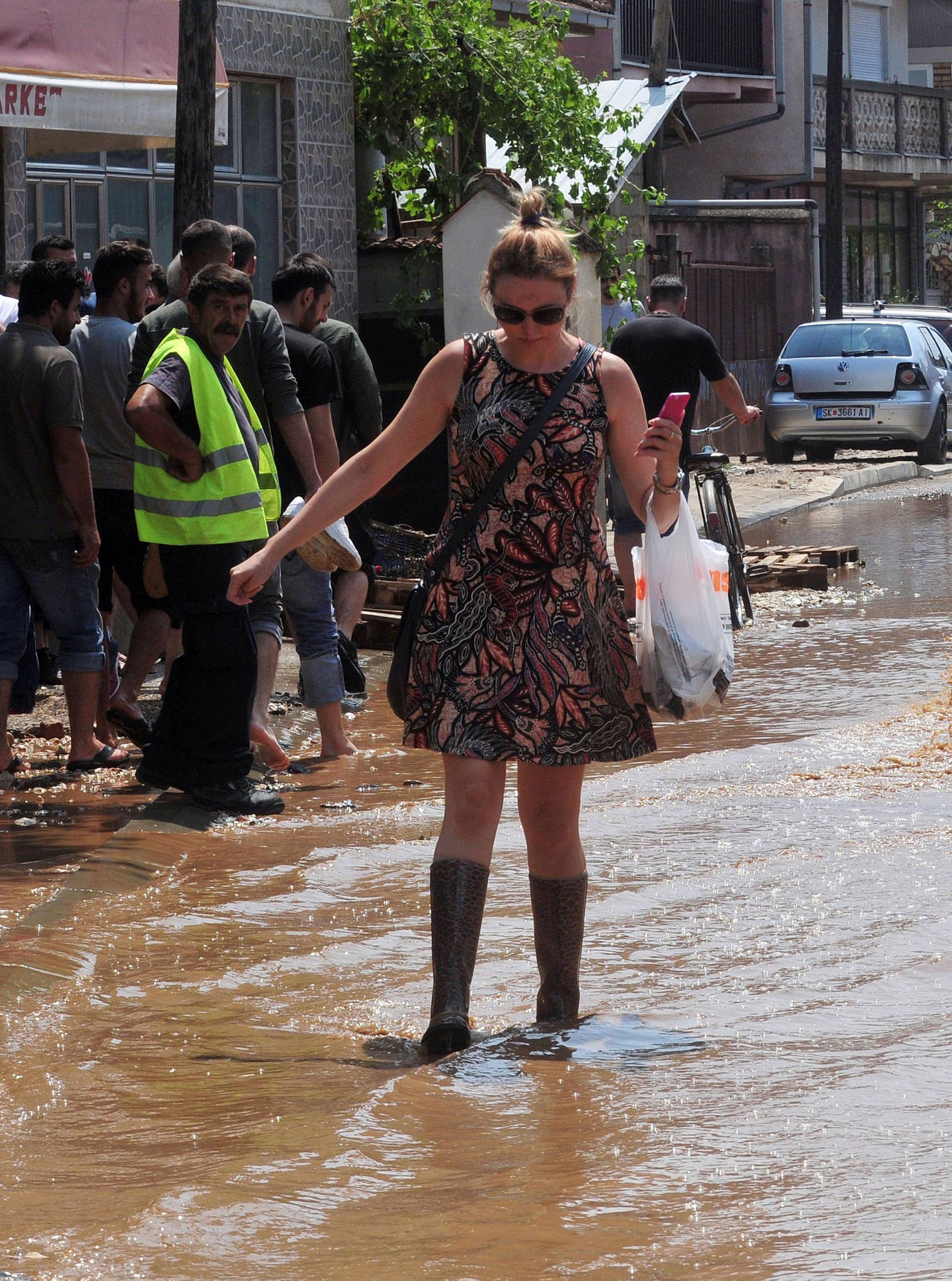 A woman wallks on the street after heavy floods in Cento 