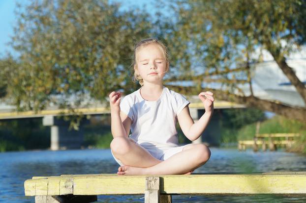 baby yoga Lotus pose.. a child practicing yoga outdoors