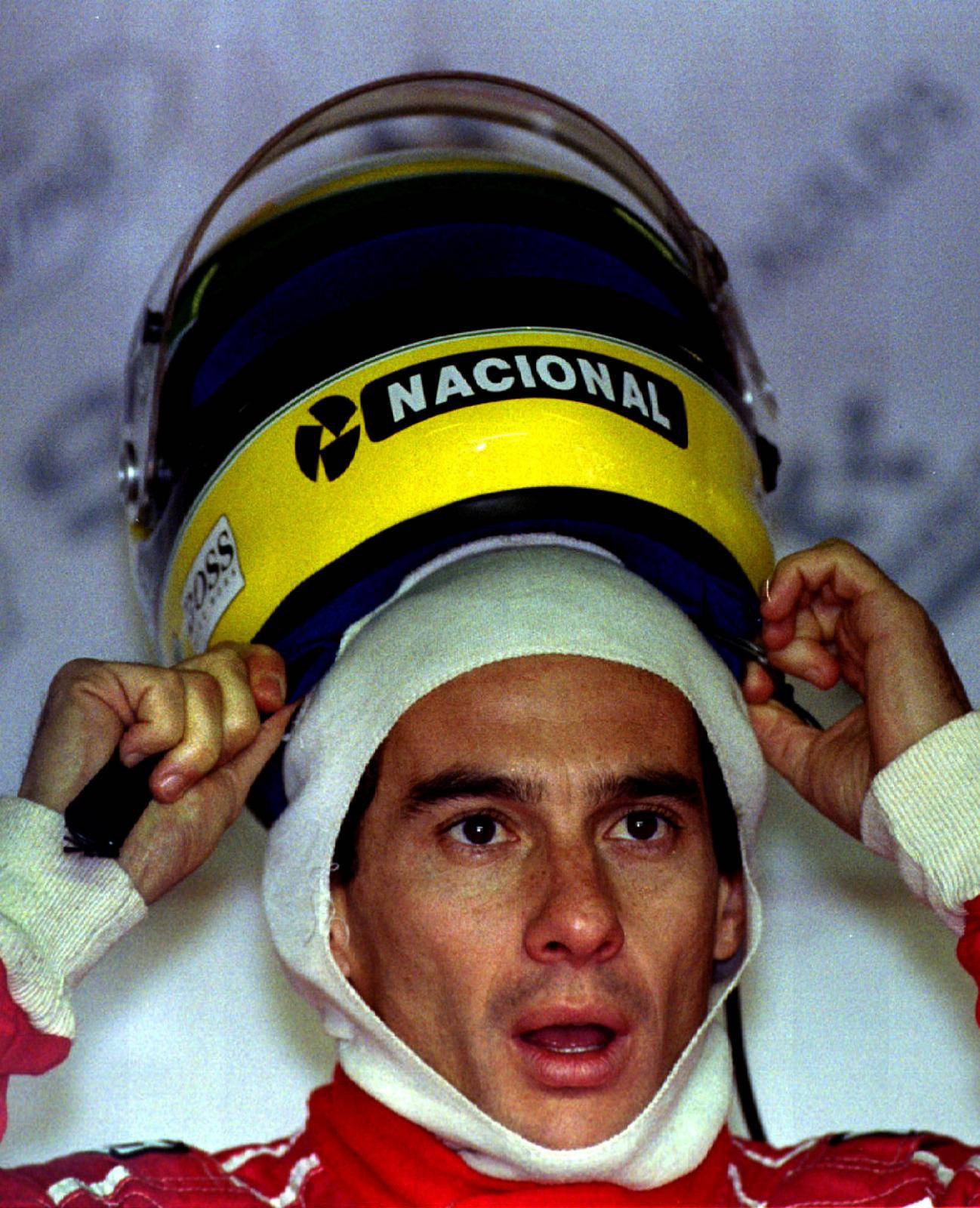FILE PHOTO: Brazil's Ayrton Senna pulls on his helmet prior to the start of the practice session July 10. Senna ..