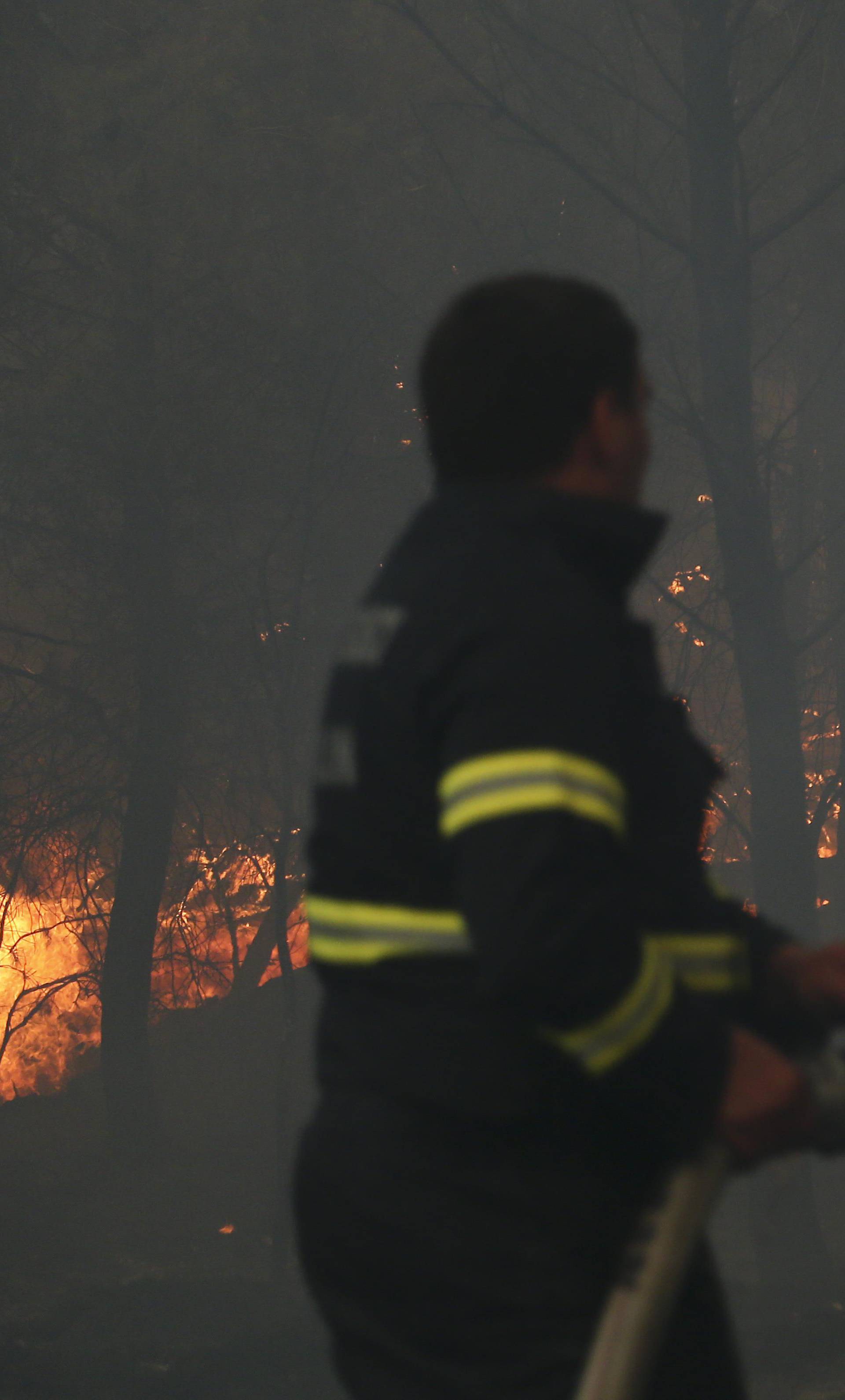 A firefighter tries to extinguish a wildfire in the village of Mravince near Split
