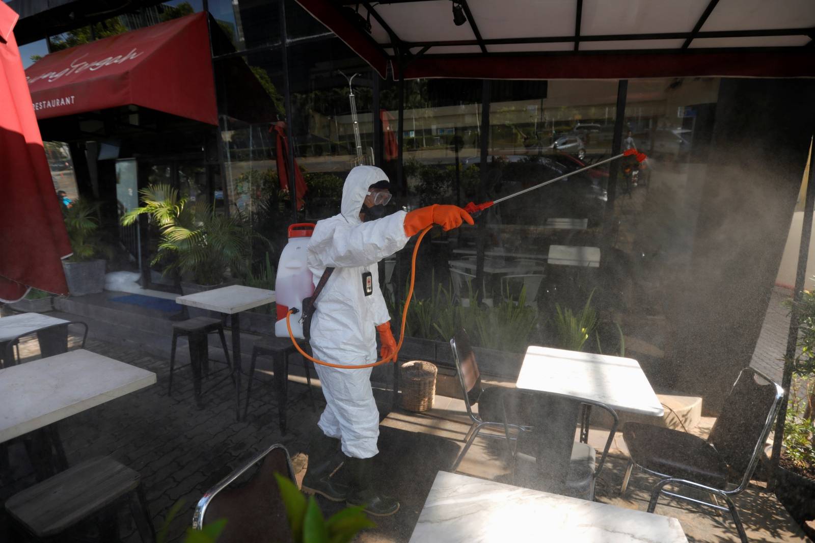 Indonesia's Red Cross personnel sprays disinfectant outside a restaurant at a department store amid the spread of coronavirus (COVID-19) in Jakarta