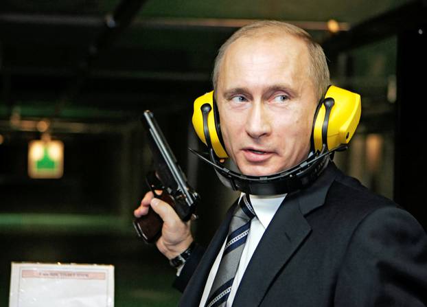 FILE PHOTO: Russian President Putin stands with a gun at a shooting gallery in Moscow