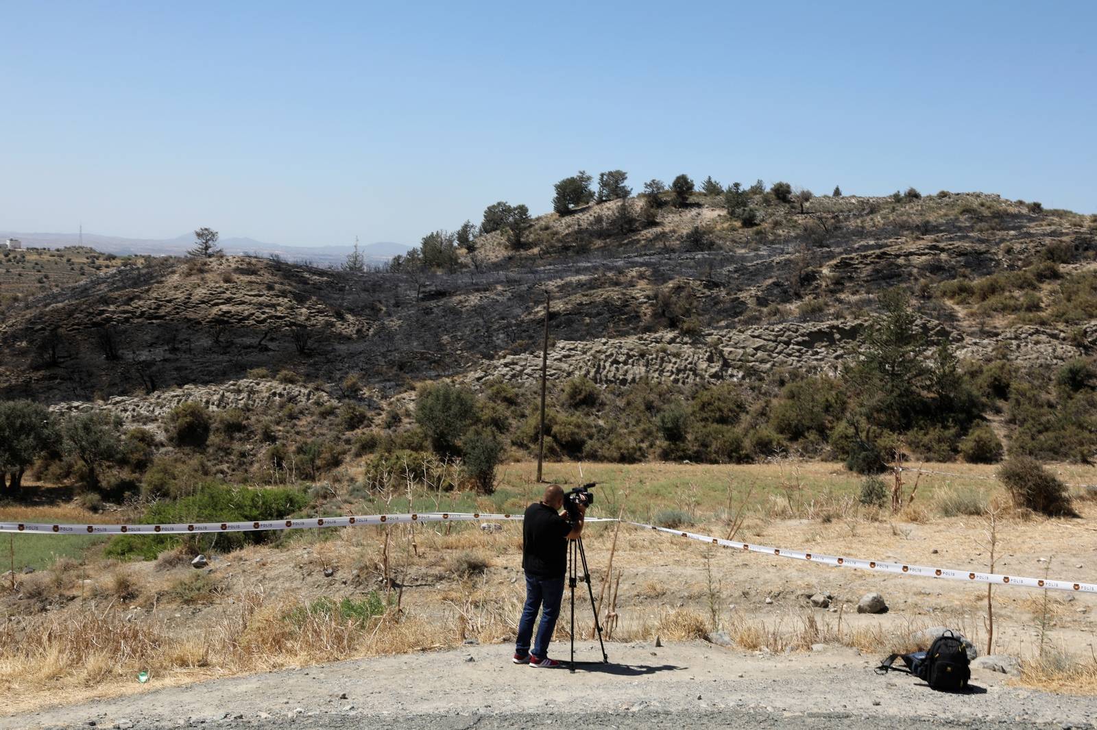 A cameraman films next to a slope where a missile struck in  Tashkent (also known as Vouno), in northern Cyprus