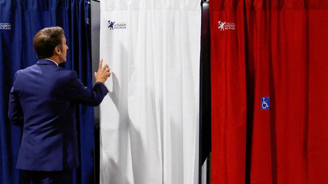 FILE PHOTO: French President Macron votes in the first round of French parliamentary elections