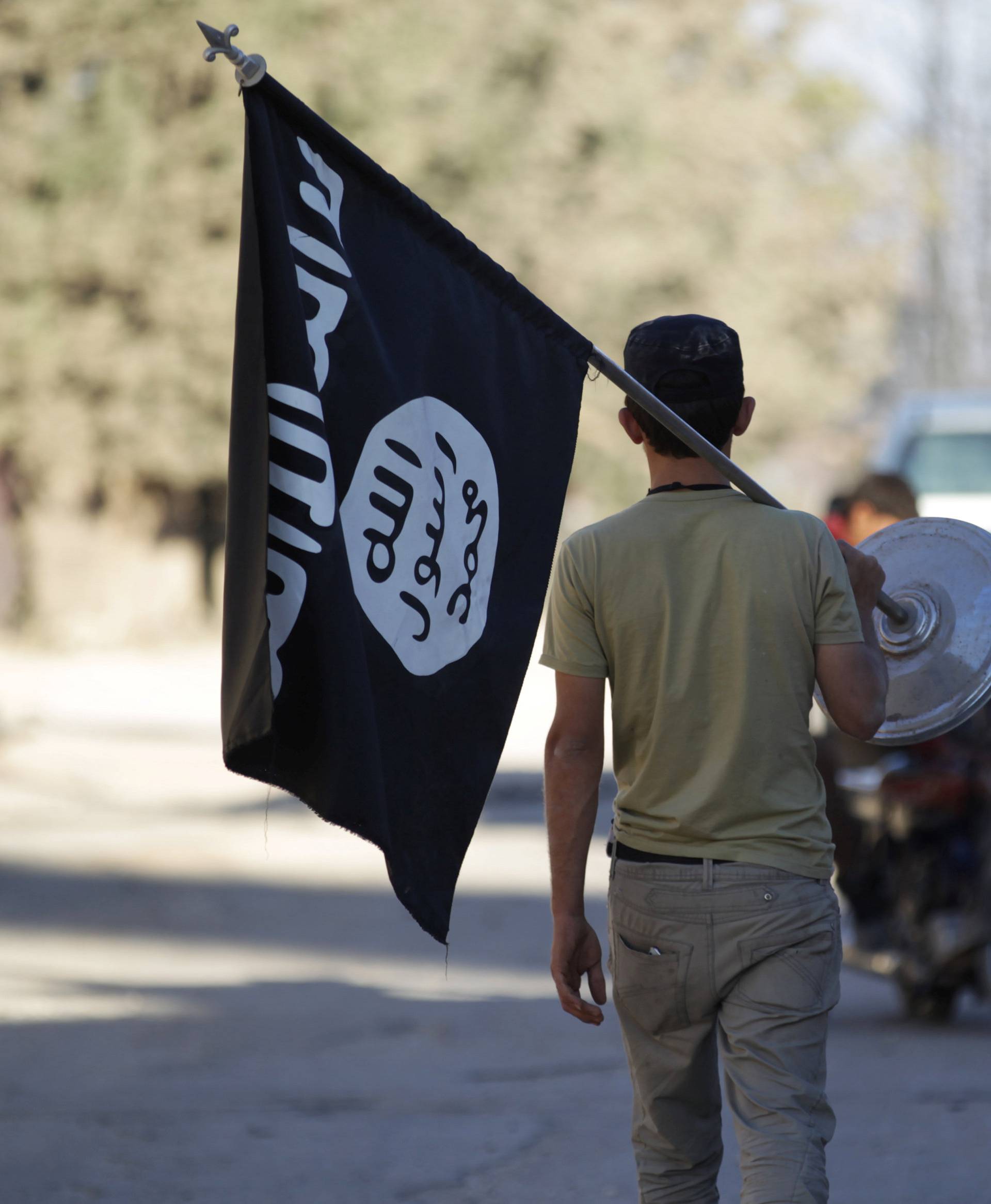 A rebel fighter takes away a flag that belonged to Islamic State militants in Akhtarin village, after rebel fighters advanced in the area, in northern Aleppo Governorate