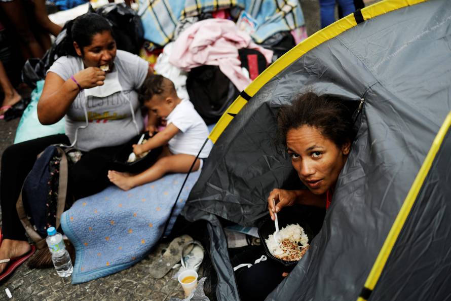 Homeless families that were living in the building that caught on fire, have lunch donated by well-wishers, next to a church at Largo do Painsandu Square in Sao Paulo