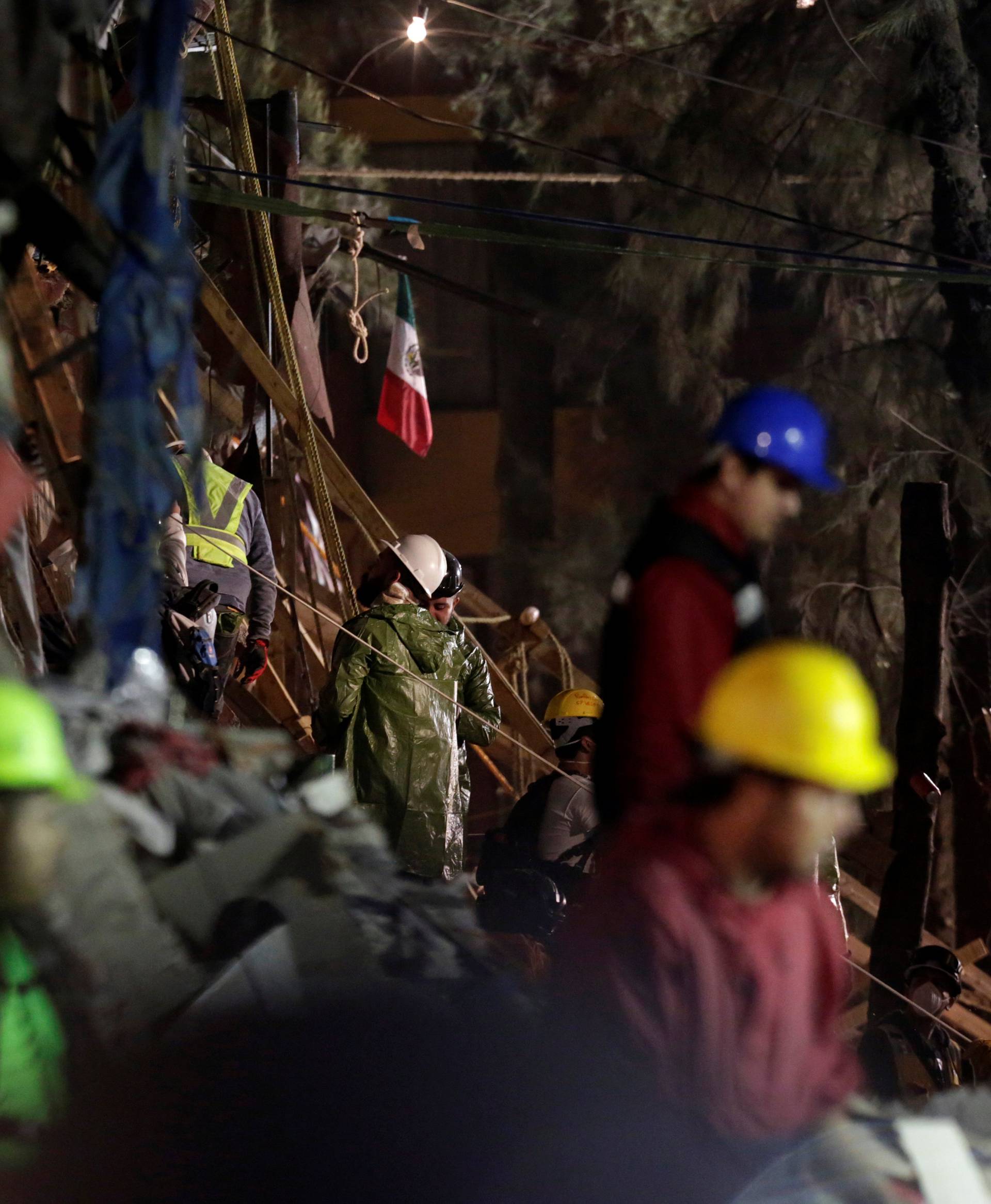 Rescue workers stand next to the rubble of a collapsed multi family residential after an earthquake in Mexico City