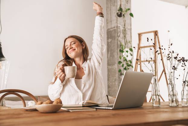 Redhead business woman stretching drinking coffee.