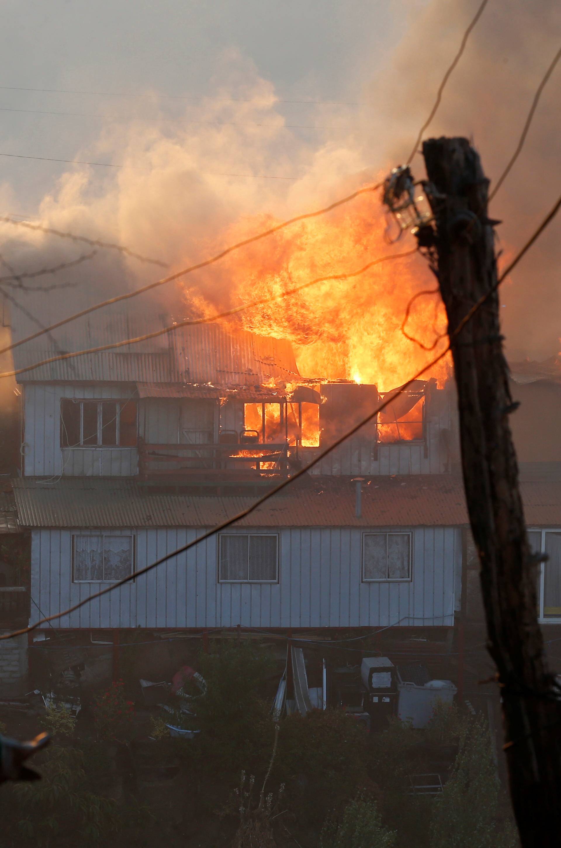 A house burns following the spread of wildfires in Valparaiso