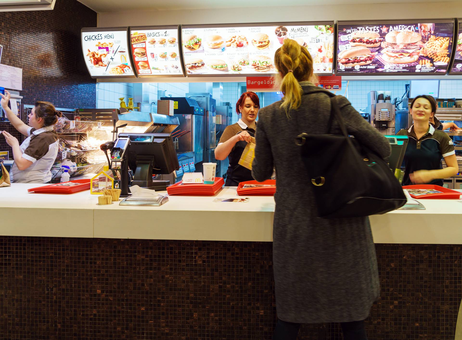 The girl receives an order in the interior of the McDonald's, Munich, Germany