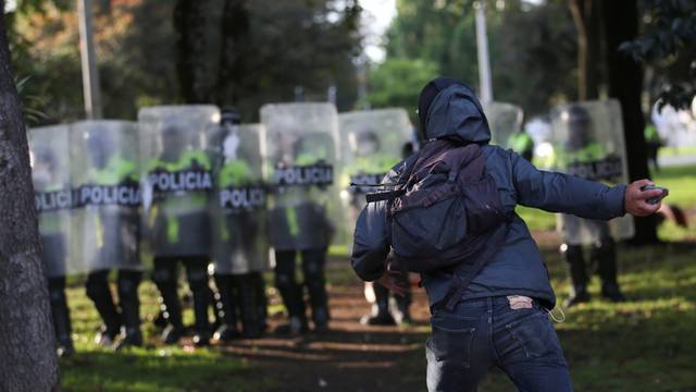 A demonstrator faces police during clashes after a man, who was detained for violating social distancing rules, died from being repeatedly shocked with a stun gun by officers, according to authorities, in Bogota