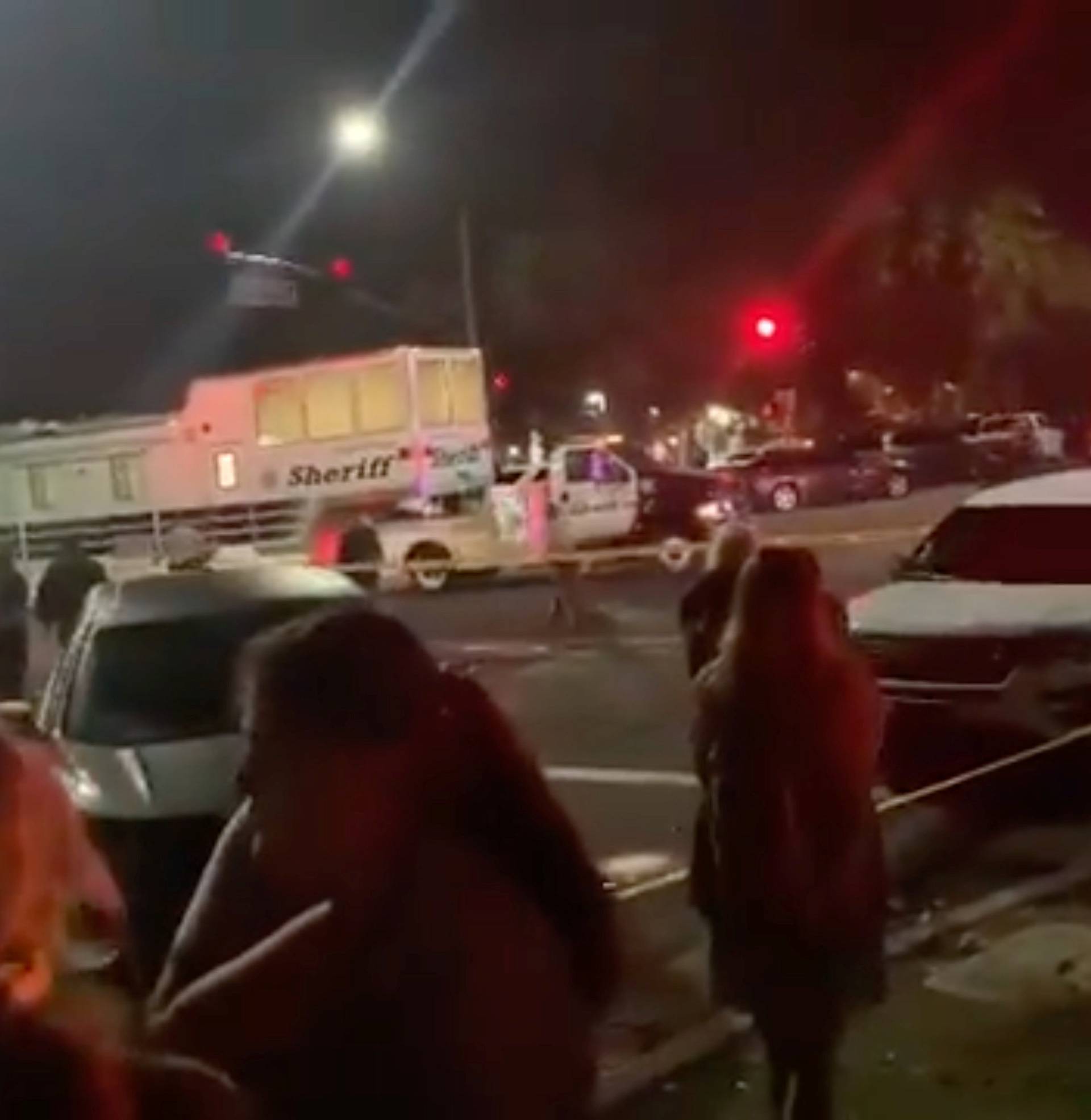 People stand behind cordon tape after the shooting in Thousand Oaks, California