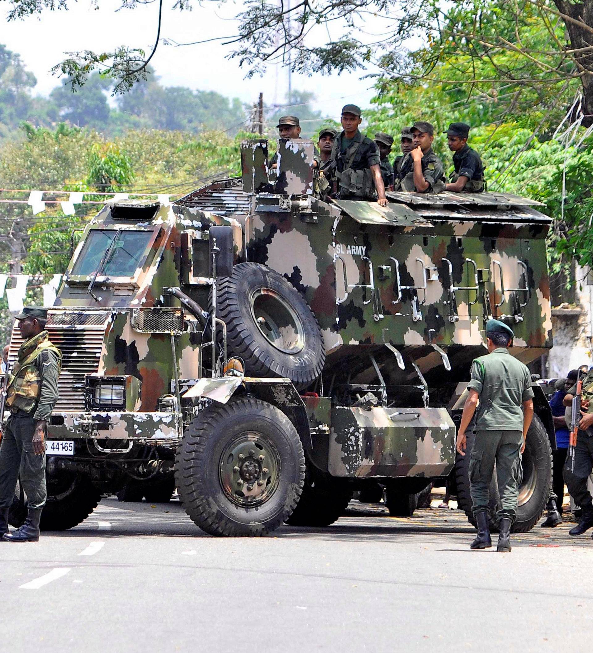 Sri Lanka's army soldiers stand guard a road after a clash between two communities in Digana