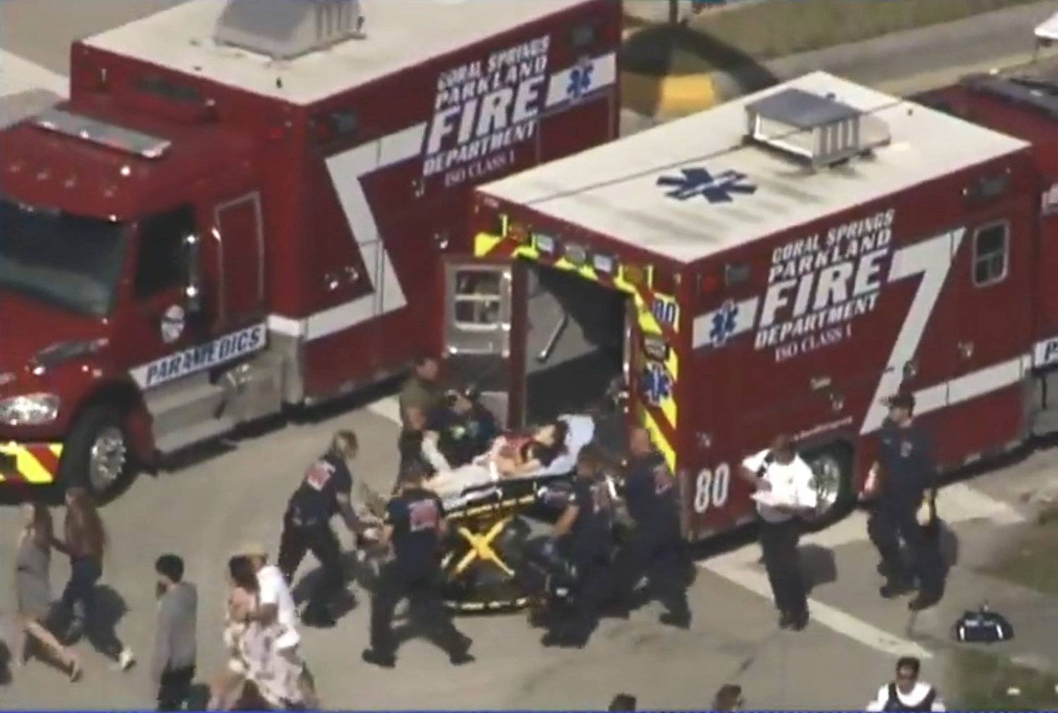 Rescue workers prepare to transport a victim on a stretcher near Marjory Stoneman Douglas High School following a shooting incident in Parkland