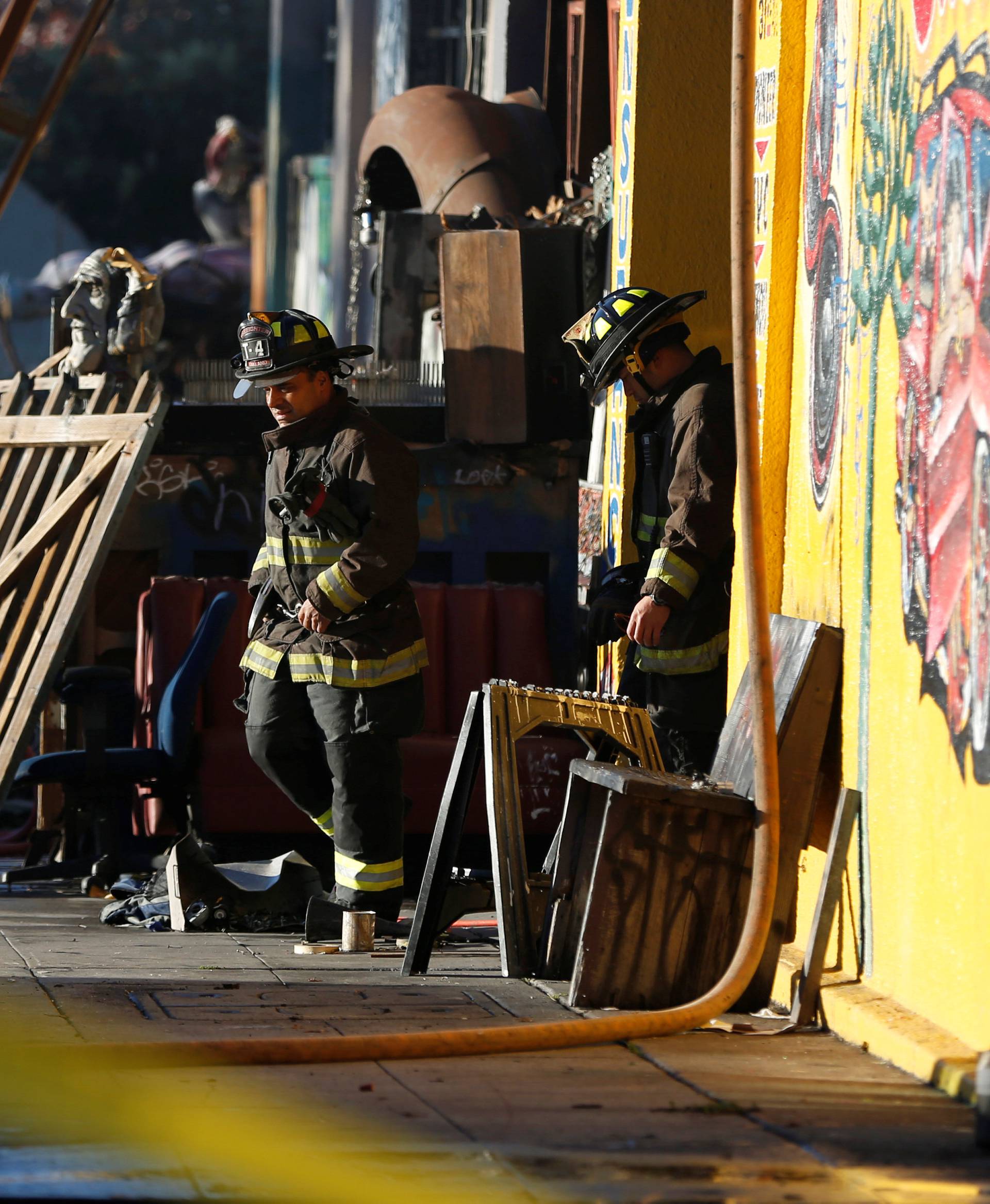 Firefighters exit a warehouse where a fire broke out during an electronic dance party late Friday evening, resulting in at least nine deaths and many unaccounted for in the Fruitvale district of Oakland, California