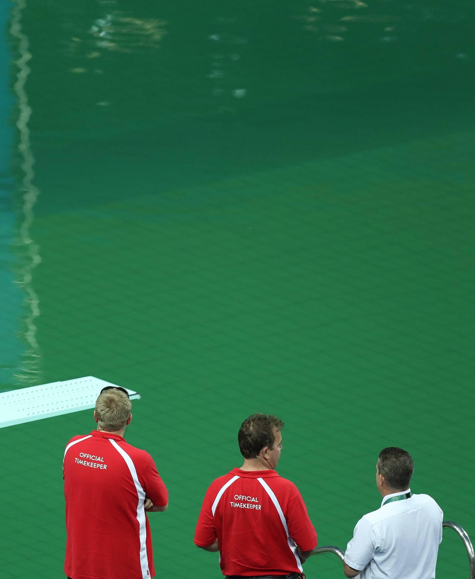 Officials look at Olympic diving pool at Maria Lenk Aquatics Centre in Rio